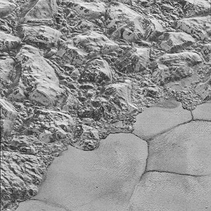 Mountains of ice along a portion of smoother ice planes on Pluto’s surface.